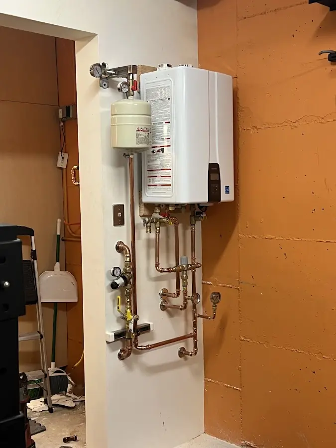 Plumbing technician inspecting water heater connections in Artesia